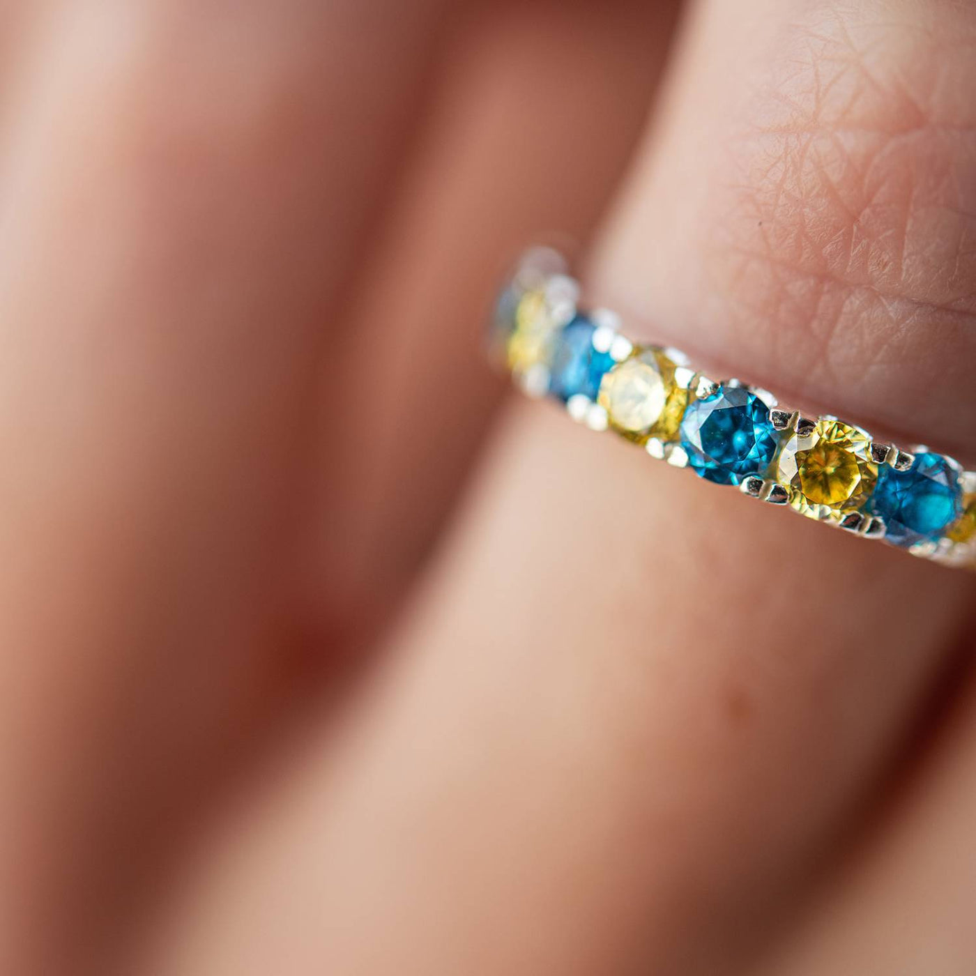 Ring with a path of blue and yellow cubic zirconia